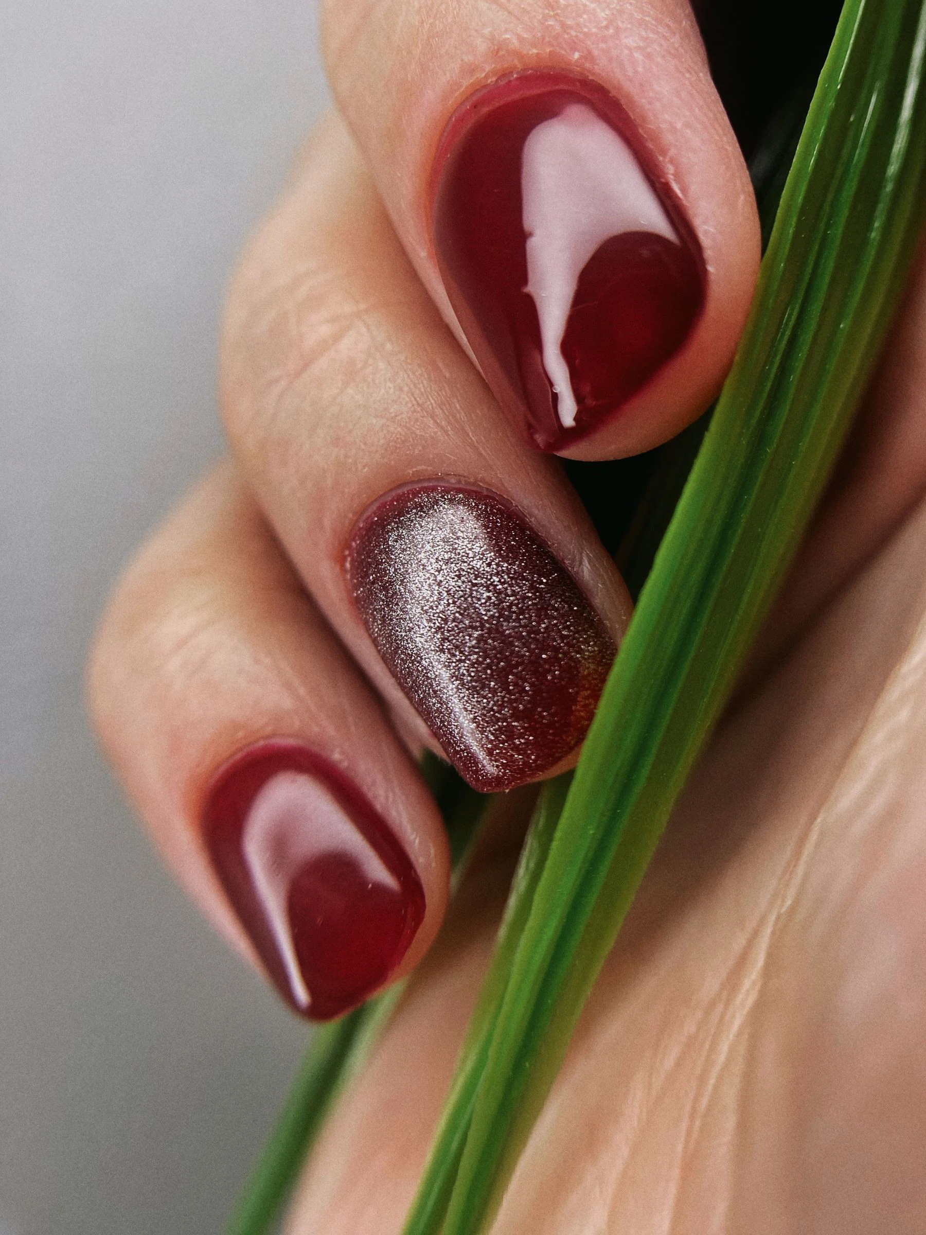 Glossy burgundy manicure with a shimmer accent nail